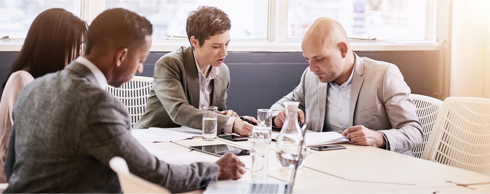 Colleagues gathered around a table while having a meeting.
