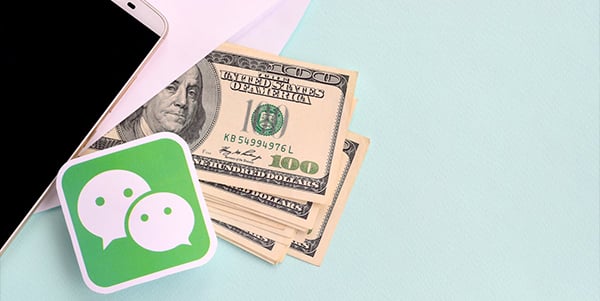 A phone, envelope with bank notes and a WeChat logo appearing.